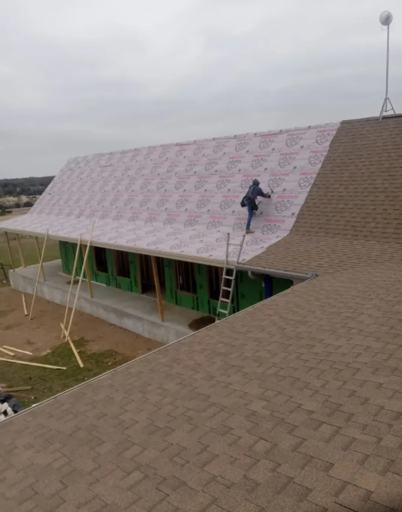 Worker preparing underlayment for a metal roof installation in Maple Shade